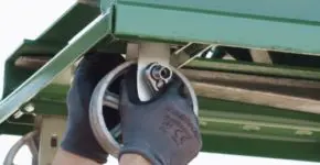 A person wearing gloves installs casters