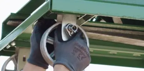 A person wearing gloves installs casters