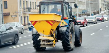 A tractor with a mounted hopper, getting ready to spread salt on roads