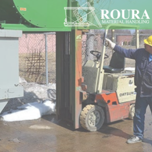 A man is using the pull down latch system on a self-dumping hopper