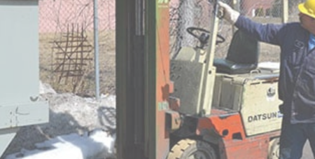 A man is using the pull down latch system on a self-dumping hopper