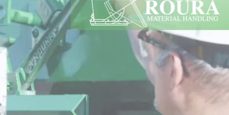 An operator has his hands on the safety latch of a self-dumping hopper