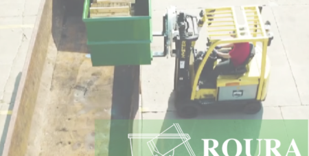 An operator holds a Roura rotator box on a forklift and is positioning it above a container
