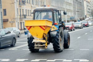 A tractor with a mounted hopper, getting ready to spread salt on roads